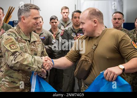 Un soldato ucraino ferito mentre combatteva l'invasione russa dell'Ucraina, scuote le mani con gli Stati Uniti Robert Lankford, comandante della 437th Airlift Wing, mentre visitava la 15th Airlift Squadron presso la Joint base Charleston, South Carolina, 22 febbraio 2023. I soldati si trovano negli Stati Uniti per essere dotati di protesi e per essere sottoposti a riabilitazione. Foto Stock