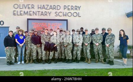 I marinai DI SAN DIEGO (27 gennaio 2023) assegnati alla nave d'assalto anfibio USS Essex (LHD 2) e il personale della Oliver Hazard Perry Elementary School posano per una foto durante un evento di volontariato, il 27 gennaio 2023. Essex è ancorata a secco a San Diego, durante un periodo di manutenzione per aggiornare e rinnovare molti sistemi chiave a bordo. Foto Stock