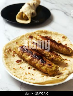 Koobideh Kebab persiano di Chichen. Kebab con curcuma, cipolle, Sumac e altri ingredienti. Su pane di lavash Foto Stock