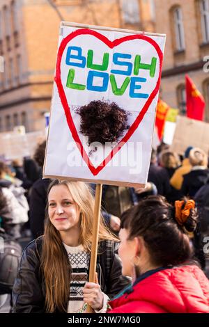 Berlino, Germania 3/8/2020 Giornata internazionale della donna marzo. Una giovane donna ha un segno di protesta improvvisato che recita “l’amore del cespuglio”. Donne giorno di combattimento 8M Foto Stock