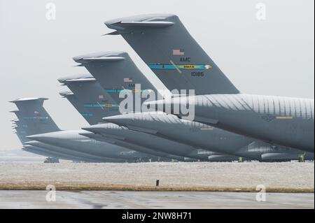 Code di velivoli Super Galaxy C-17 Globemaster III e C-5M leggermente innevati siedono sulla linea di volo alla base dell'aeronautica militare di dover, Delaware, 1 febbraio 2023. Una traccia di neve è caduta alla base, rendendola la prima nevicata della stagione. Foto Stock