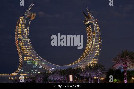 Katara Hospitality Tower, o Lusail Katara Hotel North Tower a Lusail, Qatar al tramonto, che mostra l'architettura unica della torre illuminata Foto Stock