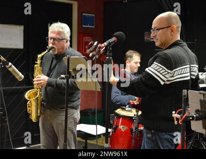 VICENZA, Italia - Simone Rossetto, un sassofono italiano, lasciato, suona con altri musicisti italiani, mentre controlla il sistema audio per la prima edizione del Music Café 22 gennaio 2023. L'evento mensile ritorna al Teatro dei soldati dopo una pausa di due anni per la pandemia. "Ho sempre amato le jam session", ha detto Rossetto. “Non ho mai perso questo appuntamento, soprattutto per la sua piacevole atmosfera e per la grande opportunità di incontrare altri musicisti che conosco. Spero che continuerà a succedendo". Foto Stock