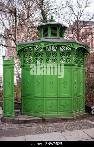 Iconici servizi igienici pubblici installati nella città di Berlino a metà del 19th ° secolo. Verde orinatoio pubblico o pissoir conosciuto come Waidmannslust o caffè ottagono Foto Stock