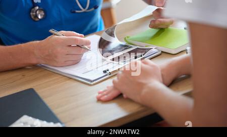 Ginecologo uomo che esamina i risultati della diagnostica ecografica degli organi pelvici Foto Stock