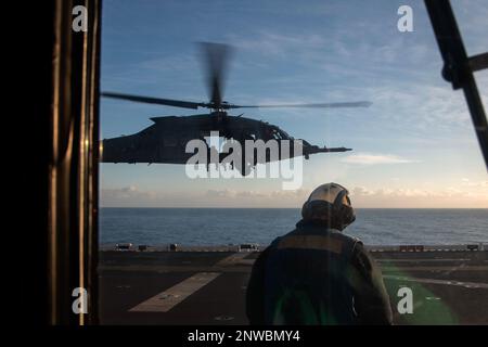 230122-N-XN177-1345 OCEANO PACIFICO (22 GENNAIO 2023) – STATI UNITI Air Force HH-60 nave Hawk elicottero assegnato al 66th Rescue Squadron decollo da anfibio attacco portatore USS Tripoli (LHA 7) 22 gennaio 2023. Tripoli sta conducendo operazioni di routine nella U.S. 3rd Fleet. Foto Stock