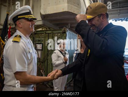 Il capitano Tony Chavez, comandante della nave d'assalto anfibio USS Makin Island (LHD 8), presenta un cappellino di comando a Jonathan Kaplan, ambasciatore degli Stati Uniti a Singapore, durante un ricevimento sponsorizzato dall'ambasciata degli Stati Uniti a Singapore, il 10 gennaio 2023. L'ambasciatore Kaplan è stato l'ospite della serata. Il Makin Island Amphibious Ready Group, composto da Makin Island e dal porto di trasporto anfibio USS Anchorage (LPD 23) e USS John P. Murtha (LPD 26), opera nell'area delle operazioni della flotta degli Stati Uniti 7th con l'unità marittima di spedizione 13th imbarcata per rafforzare la cooperazione con gli alleati e i partner A. Foto Stock