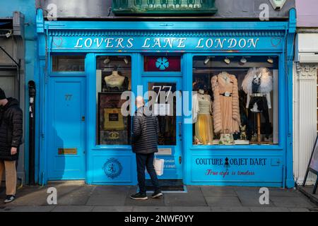 Uomo che guarda la vetrina del negozio d'epoca Lovers Lane designer al 77 Portobello Road nel quartiere di Notting Hill di Londra, Inghilterra Foto Stock