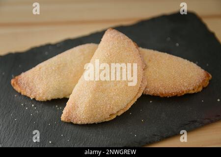 Ancora vita di alcune dolci di patate dolci, un dolce tradizionale durante il Natale a Valencia (Spagna), su un tavolo nero ardesia con spazio copia Foto Stock