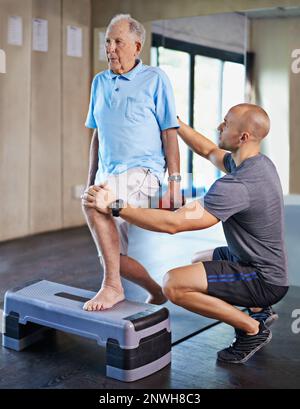 Il lungo cammino verso la riabilitazione. Scatto ritagliato di un bel personal trainer con un uomo anziano. Foto Stock