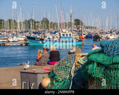 Famiglia seduto sulla banchina del porto di Lymington e del porto turistico Foto Stock
