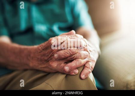 Le tue mani parlano mille parole. Scatto corto di un maschio anziano irriconoscibile seduto con le mani sul ginocchio al coperto. Foto Stock