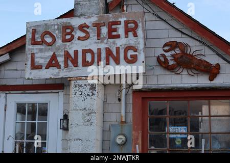 Primo piano dell'esterno di Lobster Landing a Clinton, Connecticut, USA. La foto mostra un cartello, un'aragosta metallica e la parte superiore di una porta e di una finestra. Foto Stock