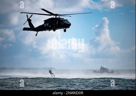 Un membro del team di salvataggio degli ostaggi dell'FBI si prepara a sollevare bagnini in un H-60m Black Hawk durante un esercizio di addestramento nell'Oceano Atlantico, il 4 agosto 2022. I membri del team di salvataggio degli ostaggi dell'FBI si allenano in diversi scenari di salvataggio in acqua con l'aiuto di più risorse locali per acquisire esperienza pratica nell'Oceano Atlantico, il 4 agosto 2022. Le agenzie esterne che sostengono questo addestramento hanno incluso il reparto del South Carolina delle risorse naturali, la divisione di applicazione di legge del South Carolina, la Charleston Fire Medical Unit, la Charleston Police Harbor Patrol, la Charleston County Sheriff's Office Marine Patrol Foto Stock