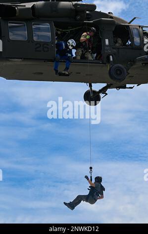 Un membro della squadra di salvataggio degli ostaggi dell'FBI fa scalzare un altro membro dell'FBI HRT fino a una barca di polizia del porto di Charleston da un H-60 M Black Hawk mentre conduce un addestramento con le agenzie locali di Charleston nell'Oceano Atlantico, 2 agosto 2022. Le agenzie esterne che sostengono questo addestramento hanno incluso il Dipartimento delle risorse naturali del South Carolina, la Divisione di applicazione della legge del South Carolina, la Charleston Fire Medical Unit, Charleston Police Harbor Patrol, Charleston County Sheriff's Office Marine Patrol, Mount Pleasant Police Department Marine Patrol, Charleston County Volunteer Rescue Squad, North Charleston Police Marine Foto Stock