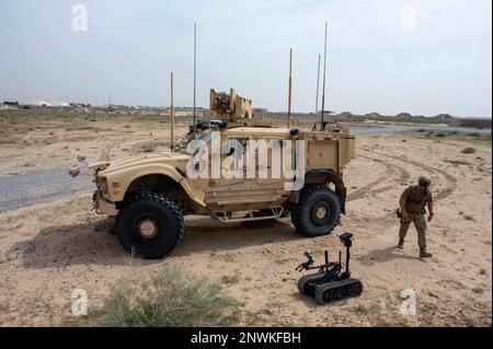 STATI UNITI Domenic Martino, un tecnico di smaltimento di ordigni esplosivi del 386th Expeditionary Civil Engineering Squadron, passa davanti a un veicolo All Terrain resistente alle mine e verso un robot TALON® durante un esercizio di risposta Unmanned Aircraft Systems presso la base aerea di Ali al Salem, Kuwait, 21 febbraio 2023. Gli eventi simulati consentono ad Airmen di sviluppare le proprie competenze critiche per scenari reali in un ambiente controllato, pur avendo la capacità di lavorare in situazioni stressanti. Gli esercizi a livello di base forniscono ad Airmen la capacità di esercitarsi per le minacce del mondo reale e per altri scenari realistici Foto Stock