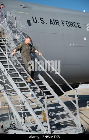 Tony Parris, 77th Air Refuelling Squadron boom operator, esce da un KC-46A Pegasus dopo il suo volo fini alla base dell'aeronautica militare Seymour Johnson, North Carolina, 5 gennaio 2023. Parris è stato accolto e calato con acqua e champagne dalla sua famiglia e da altri membri del servizio al termine del volo fini. Foto Stock