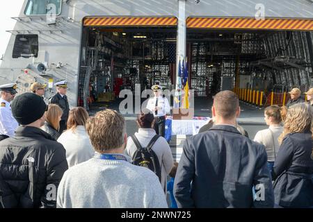 230111-N-ZS023-0004 SAN DIEGO (11 gennaio 2023) Royal Australian Navy Commodore Darren Grogan, centro, l'addetto navale australiano per gli Stati Uniti, consegna osservazioni a australiani e statunitensi Marinai, personale del Centro di manutenzione Regionale del Sud-Ovest e familiari a bordo della nave da combattimento litoranea variante Independence USS Canberra (LCS 30) durante una cerimonia promozionale sul ponte di volo della nave, il 11 gennaio. Homeported in San Diego, California, Canberra è una parte di Littoral Combat Ship Squadron One. La nave è programmata per entrare ufficialmente nella flotta e per condurre la cerimonia di messa in servizio nel corso di quest'anno. Foto Stock