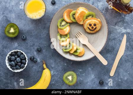 Frittelle fatte in casa a forma di bruco con frutta e succo di frutta. Foto Stock