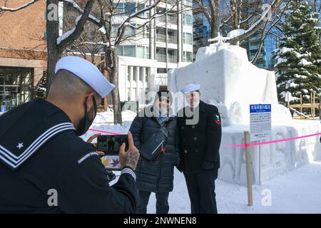 SAPPORO, Giappone (4 febbraio 2023) - Operations Specialist 2nd Class Daveon Fitzgerald, assegnato al Comandante Task Force sette due, scatta una foto di Aviation Support Equipment Technician 2nd Class Victoria Gosser, assegnato ad AIMD Misawa Japan con i locali giapponesi durante il 73rd Annual Sapporo Snow Festival. Questo è il 38th° anno in cui gli Stati Uniti Navy ha partecipato al festival, consentendo ai marinai un'opportunità unica di vivere la cultura e la tradizione giapponese rafforzando la stretta amicizia tra gli Stati Uniti Marina e i cittadini del Giappone. Foto Stock