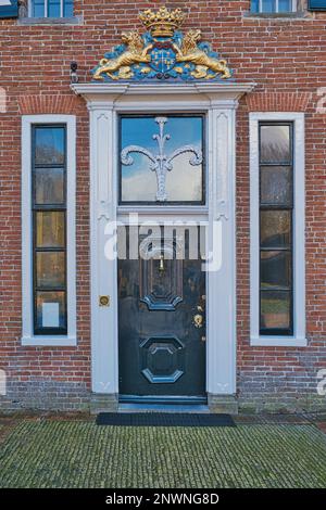 Ingresso al maniero Menkemaborg, Uithuizen, Groningen, con albero stilizzato di vita e stemma araldico Foto Stock