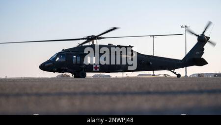 Un elicottero Blackhawk dell'esercito degli Stati Uniti UH-60 si prepara a decollare dopo un allenamento alla base aerea di Ali al Salem, Kuwait, 20 gennaio 2023. Il 405° Squadrone di evacuazione Aeromedica Expeditionary e il 386° Squadrone medico Expeditionary hanno collaborato con gli Stati Uniti Forze dell'esercito e della coalizione per praticare il carico e lo scarico di pazienti medici da un elicottero UH-60 Blackhawk. L'UH-60 è l'attuale elicottero a sollevamento medio per uso generale delle forze armate statunitensi ed è visto qui con i simboli della Croce Rossa per l'evacuazione medica. Foto Stock