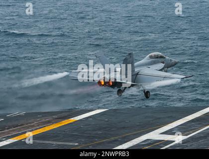 230127-N-MH015-1301 SOUTH CHINA SEA (27 gennaio 2023) un F/A-18F Super Hornet dei “Fighting Redcks” di Strike Fighter Squadron (VFA) 22 lancia dal ponte di volo della portaerei USS Nimitz (CVN 68). Nimitz è presente negli Stati Uniti nel 7th Fleet e svolge operazioni di routine. 7th Fleet è la flotta statunitense La flotta numerata più grande della Marina e interagisce e opera regolarmente con alleati e partner per preservare una regione indomorosa e libera. Foto Stock