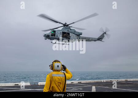 MARE DELLA CINA DEL SUD (4 GENNAIO 2023) - STATI UNITI Navy Aviation Boatswain’s Mate (handler) Tyler Perry, assegnato alla banchina di trasporto anfibio USS Anchorage (LPD 23), saluta agli Stati Uniti Marine Corps UH-1Y piloti di Venom con Marine Medium Tiltrotor Squadron (VMM) 362 (Rein.), 13th Marine Expeditionary Unit, dopo il decollo dall'Anchorage, 4 gennaio. La mobilità e la sostenibilità fornite dalle piattaforme anfibie consentono al team Navy-Marine Corps di ampliare la portata delle nostre capacità. 7th Fleet è la flotta statunitense La flotta numerata più grande della Marina, distribuita in avanti, interagisce e opera regolarmente con gli alleati AN Foto Stock