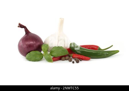 Cipolla rossa, peperoncino, rametto di basilico e bulbo d'aglio isolato su fondo bianco. Spezie e tema aromatizzante ancora vita Foto Stock