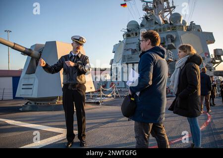 ROSTOCK, Germania (9 gennaio 2023) Lt. CMdR. Kyle Wagner, a sinistra, dà un giro del precipietto del cacciatorpediniere missilistico guidato di classe Arleigh Burke USS Roosevelt (DDG 80) al personale mediatico tedesco, 9 gennaio 2023. Roosevelt è in fase di implementazione pianificata negli Stati Uniti Naval Forces Europe area of Operations, impiegato dagli Stati Uniti Sesta flotta per difendere gli interessi degli Stati Uniti, alleati e partner. Foto Stock