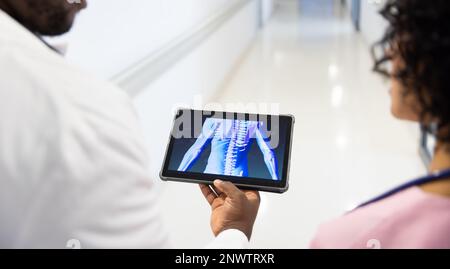 Diversi medici maschili e femminili con stetoscopi utilizzando tablet con digitale umano in ospedale. Concetto di salute, reparto ospedaliero e assistenza. Foto Stock