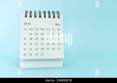 Focalizzazione selettiva del calendario da tavolo di maggio 2023 su sfondo blu con spazio per le copie. Foto Stock