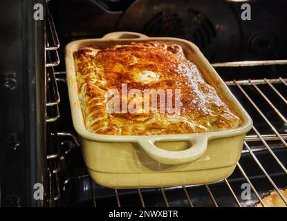 Al forno viene cotto un soufflé di patate, zucchine, cavolfiore e formaggio giallo Foto Stock