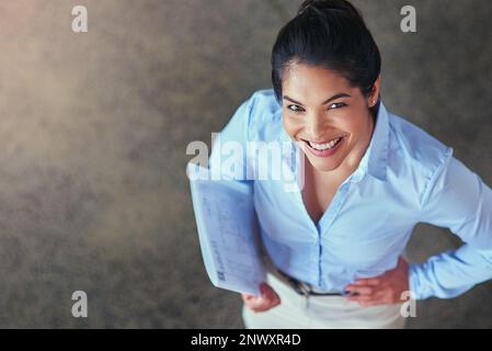 Fornisce un bene prezioso a questa azienda. Ritratto ad angolo alto di una giovane donna d'affari elegante in ufficio. Foto Stock