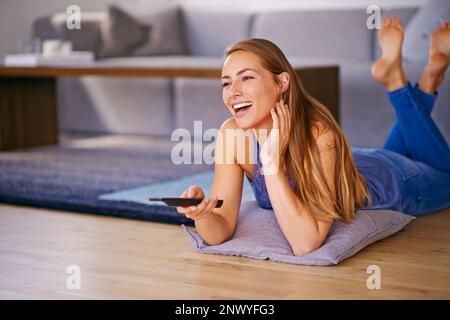 Guardare uno di quei film di sentirsi bene. una giovane donna che guarda la televisione a casa. Foto Stock