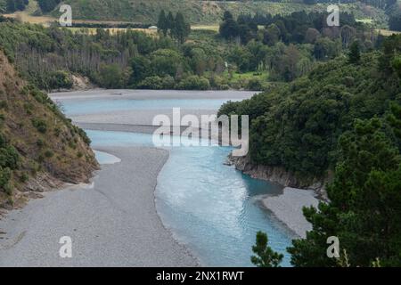 L'acqua blu del fiume Rakaia come scorre attraverso la foresta collinare della Nuova Zelanda. Foto Stock