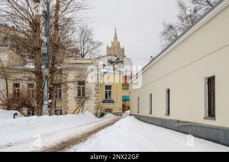 Mosca. Russia. Febbraio 25, 2023. Vista della guglia dell'edificio del Ministero degli Esteri russo che torreggia sui vecchi edifici di Mosca in una giornata invernale. Foto Stock