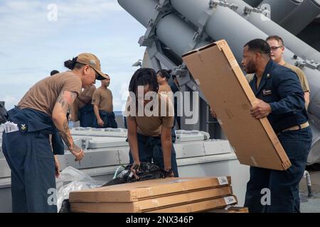 230214-N-SN516-1178 SOUTH CHINA SEA (14 FEBBRAIO 2023) USA I marinai della Marina organizzano le forniture ricevute durante un rifornimento in mare (RAS) con la flotta nave da carico a secco e munizioni USNS Amelia Earhart (T-AKE 6) a bordo del cacciatorpediniere missilistico guidato di classe Arleigh Burke USS Decatur (DDG 73). Decatur, che fa parte del Nimitz Carrier Strike Group, è in US 7th Fleet che conduce operazioni di routine. 7th Fleet è la flotta statunitense La flotta numerata più grande della Marina, distribuita in futuro, interagisce e opera regolarmente con gli alleati e i partner per preservare una regione indomPacifico libera e aperta. Foto Stock