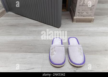 le ciabatte per la casa si trovano vicino alla soglia della casa. Foto Stock