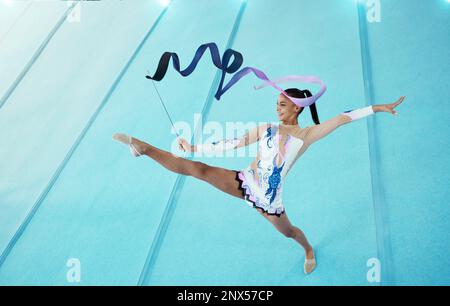 Ginnastica, donna con nastro per danza e performance sportive, flessibilità con atleta professionista in palestra e vista dall'alto. Ginnastica ritmica, gamba in aria Foto Stock