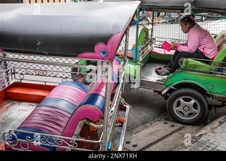 Woman,driver, waiting for customers, three wheel taxi Tuk Tuk, in Khao San Road, Bangkok, Thailand Stock Photo