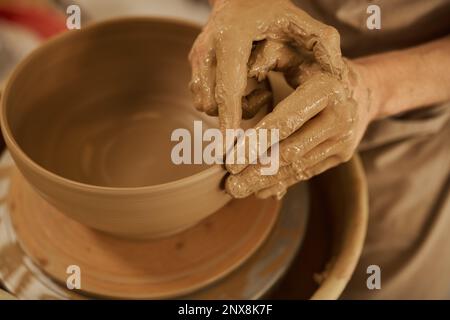 Ceramista fare una ciotola su una ruota in uno studio di ceramica Foto Stock
