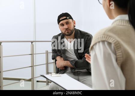 Psicoterapeuta che lavora con un giovane tossicodipendente al chiuso Foto Stock