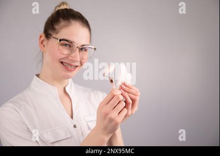 Medico estetista che tiene gouache raschietto e rullo. Foto Stock