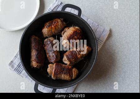 Involtini di manzo fritti in una teglia. Cucinare, fare, preparazione. Parte di una serie Foto Stock