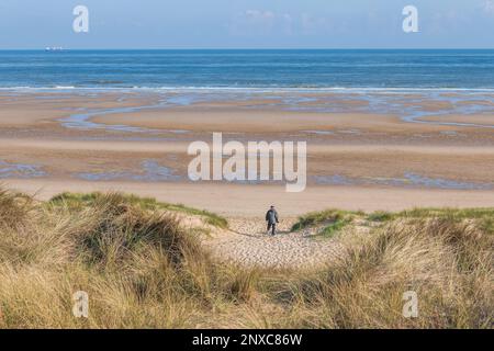 Anziano che cammina su una spiaggia Foto Stock