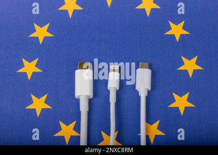 Concetto per la legislazione dell'UE di imporre i caricabatteria USB-C per tutti i telefoni. Bandiera DELL'UNIONE EUROPEA e cavo di ricarica universale USBC come standard per i dispositivi elettronici di piccole dimensioni Foto Stock