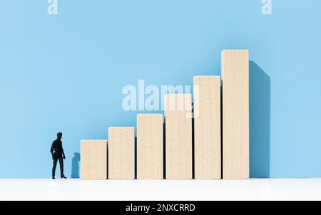 Figurina umana guardando un grafico a barre crescente. Concetto di sviluppo della carriera. Spazio di copia Foto Stock