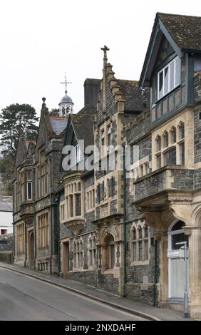 Grandi edifici antichi a Tavistock costruito su strada collinare che conduce a Brentor piccola chiesa in alto a Dartmoor Devon Foto Stock