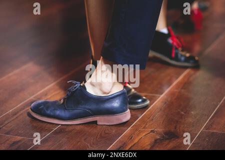 Scarpe da ballo di giovani coppie ballano balli jazz swing retrò su un locale da ballo con pavimento in legno, vista ravvicinata di una scarpa, femminile e maschile, lezioni di danza Foto Stock